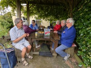 People Sat on a bench enjoying the Coffee morning.