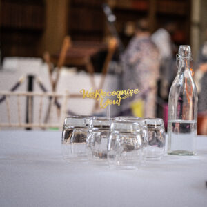 Image shows a table top with glasses and centre pieces.