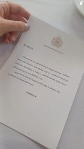Image shows a hand holding a letter from the king.