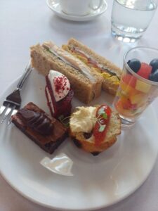 Cake, sandwiches and fruit on a plate
