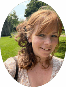 Rebecca Evans in a field with trees in the background.