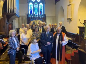 Image shows Bishop of Truro with a collection of people in a church.