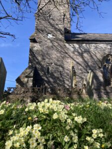 A church with a floral churchyard in front of it