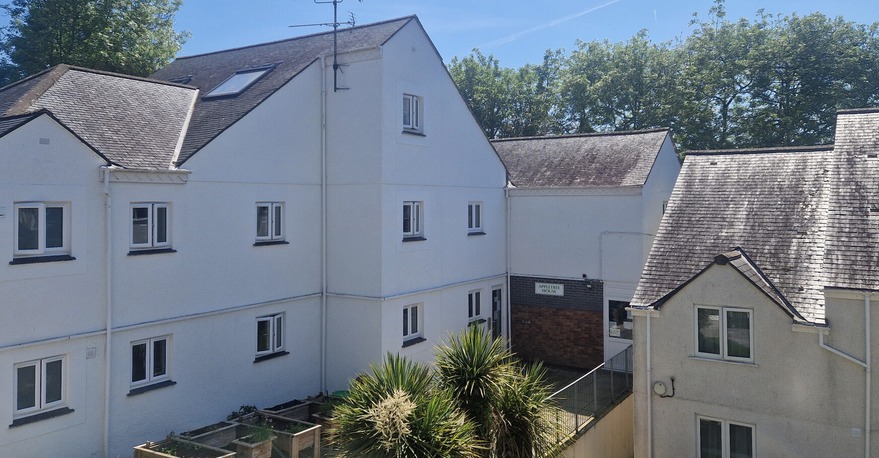 Image shows a white building with many windows.
