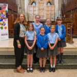 A teacher and pupils stood in the cathedral.