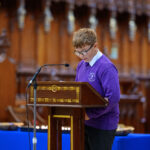 A child in purple reading from the pulpit in the cathedral.
