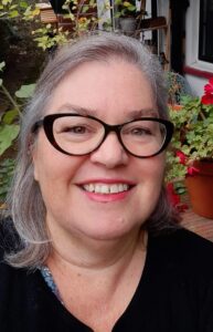 Image shows Sharon smiling at the camera.