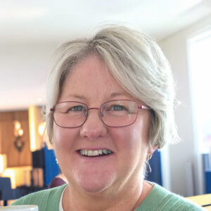 Image shows Ann looking at the camera and smiling