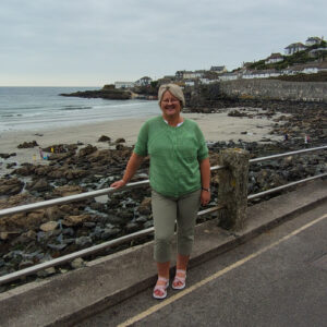 Ann stood by railings with the beach, rock pools and see beyond