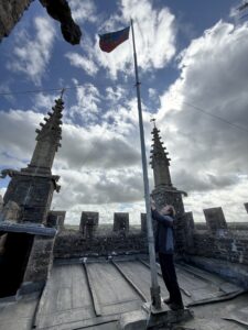 Looking up at the flag and the cloudy sky from the church tower.