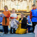 Children at the front of the church reading from paper.