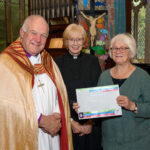 The Bishop of Truro to the left with with two others - one holding a certificate.