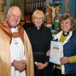 The Bishop of Truro to the left with with two others - one holding a certificate.