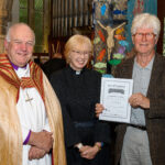 The Bishop of Truro to the left with with two others - one holding a certificate.