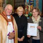 The Bishop of Truro to the left with with two others - one holding a certificate.