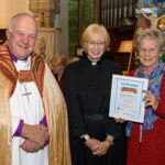 The Bishop of Truro to the left with with two others - one holding a certificate.