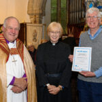The Bishop of Truro to the left with with two others - one holding a certificate.