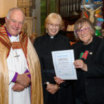 The Bishop of Truro to the left with with two others - one holding a certificate.