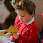 Children cutting yellow paper.