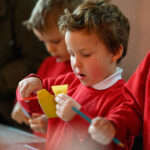 Children cutting yellow paper.