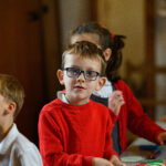 Child doing crafts looking at the camera