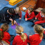 Children sat in a circle with an adult