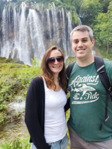 Beth and another person standing in front of a waterfall.