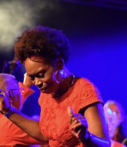 Ley in a red top with a black and blue background.