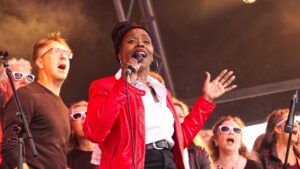 Ley singing in the choir with other members around her.