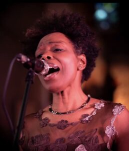 Ley singing into a microphone. 