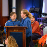 Two children speaking from the pulpit.