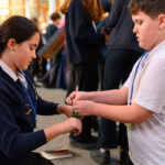 Two children tying sticks together.