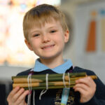 A child holding a bundle of sticks.