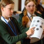 Children showing the camera their work.