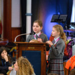 Two children speaking from the pulpit.