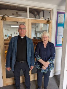 Two people stood in front of their new glass doors.